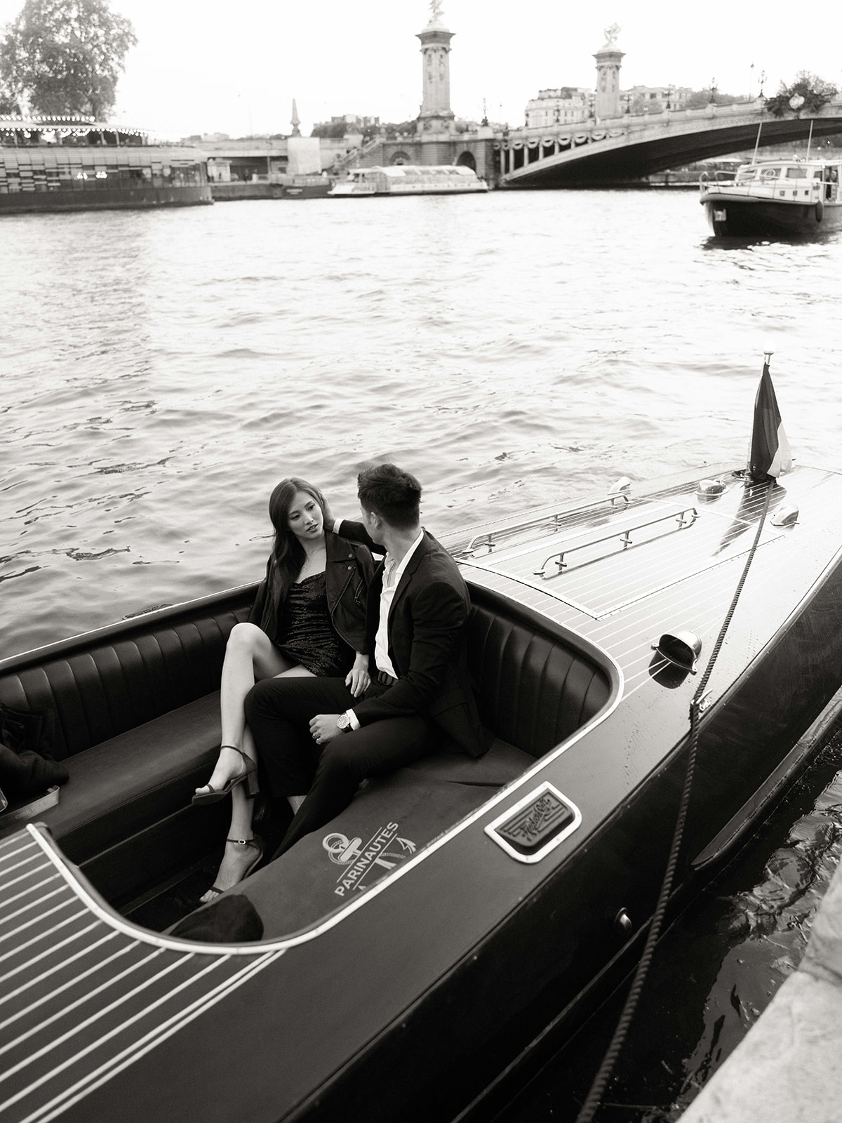 Couple seated aboard a private boat during a Seine River engagement session in Paris